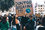 A girl holds up a home made sign saying 'Don't go breaking my world' as the marches with others at a climate protest.
